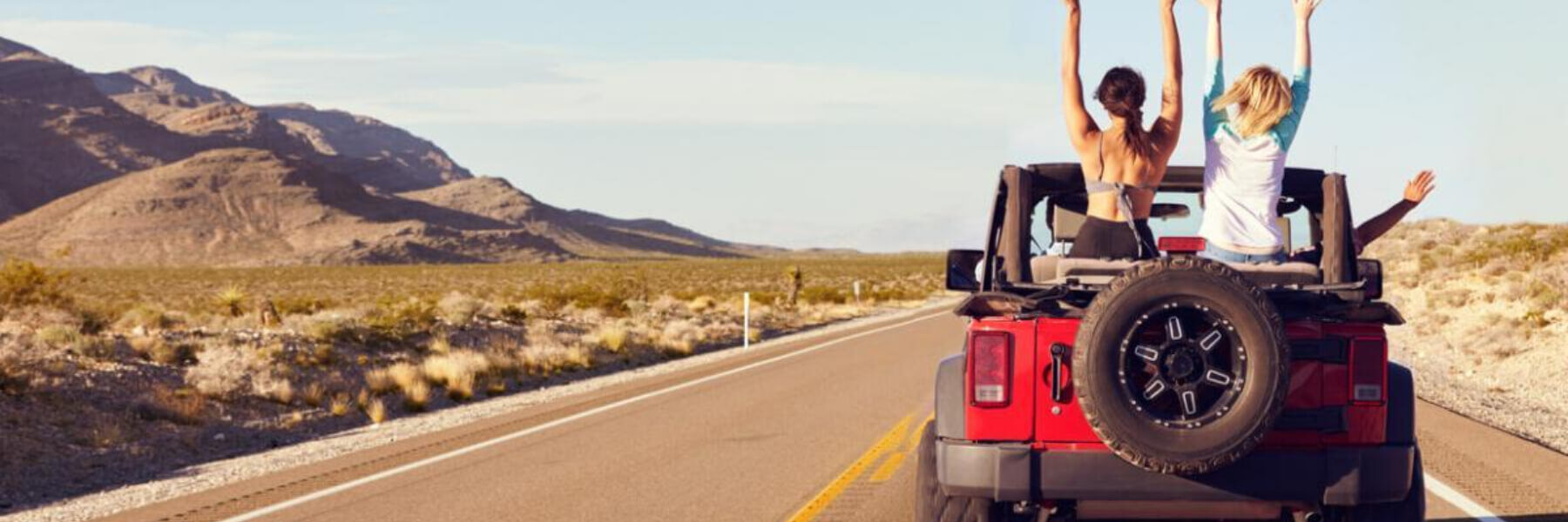 Rearview of friends driving in a convertible vehicle