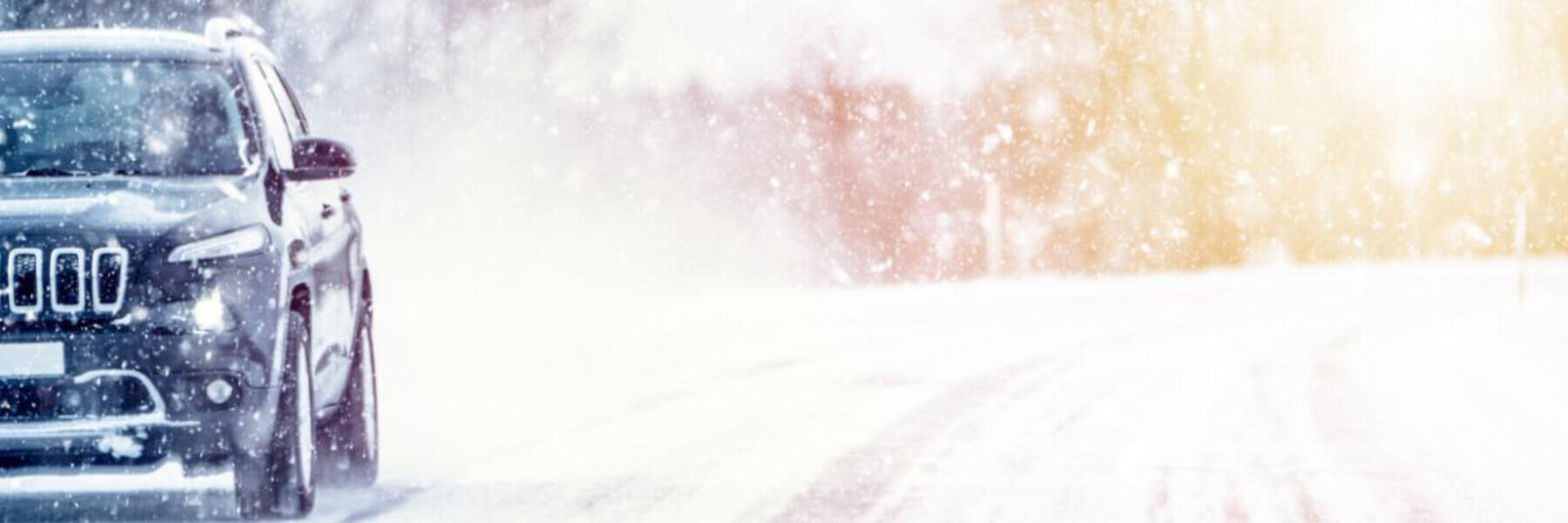 Black suv driving in the snow, winter driving concept. 